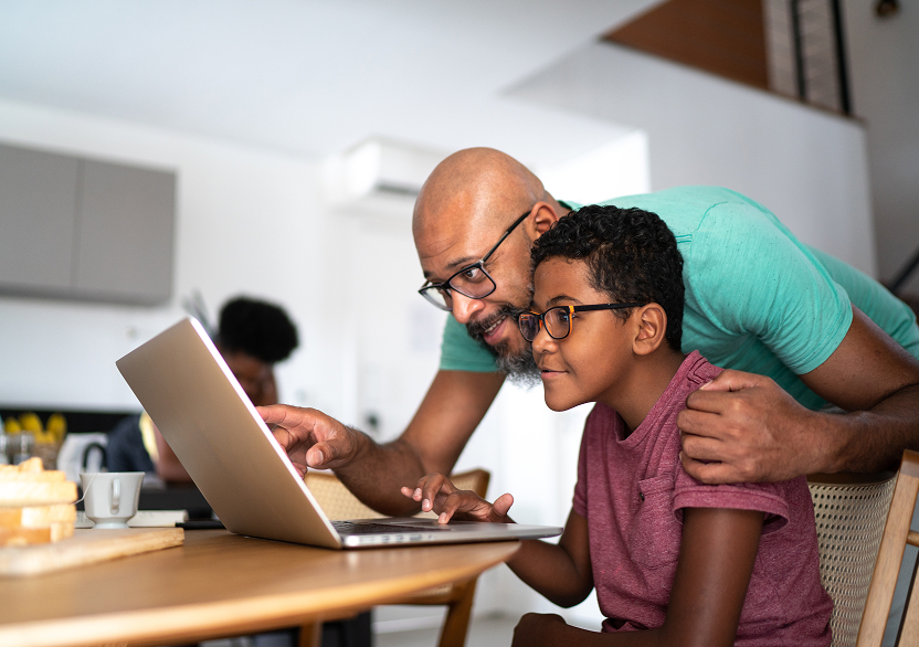 A parent and child reviewing the hemophilia Lifestyle and Treatment Quiz on a laptop