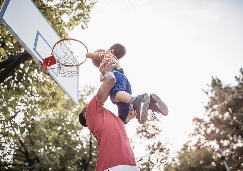A man and a boy playing basketball